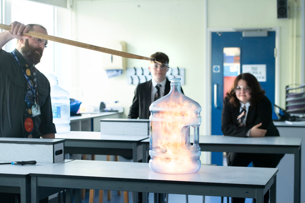 Science Teacher Demonstrating Experiment with Students Watching